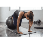 אישה מאמנת עם כדור פיאלטיס עם הדפס לתרגילים