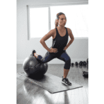 אישה מאמנת עם כדור פיאלטיס עם הדפס לתרגילים