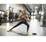 אישה מאמנת בעמידה בחדר כושר עם דיסקיות החלקה