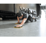 איש מאמן פלנק בחדר כושר עם דיסקיות החלקה