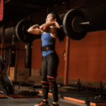 אישה מרימה משקולות עם רצועות ליפוף לברך