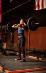 אישה מרימה משקולות עם רצועות ליפוף לברך